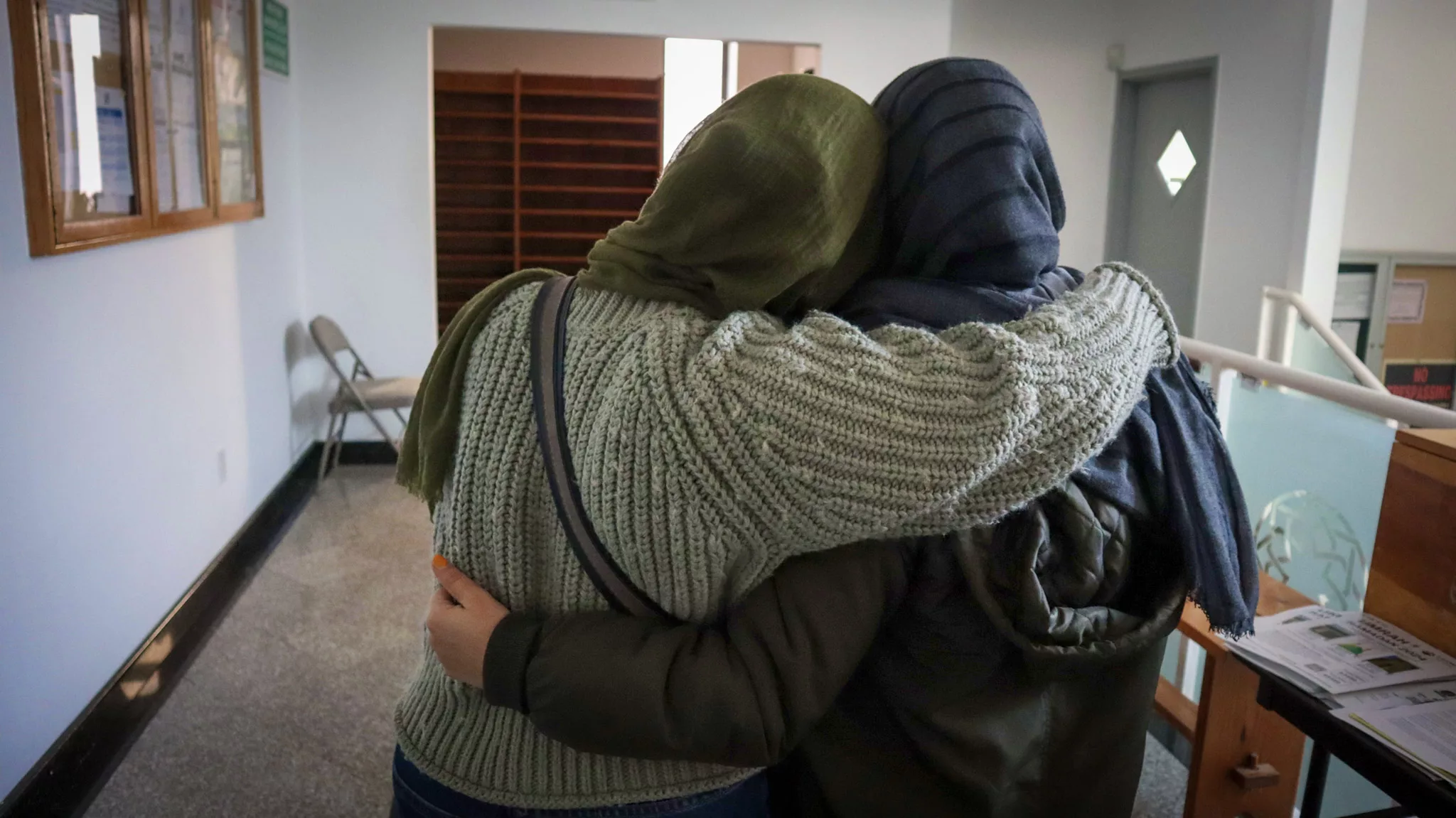 
            Two Afghan women embrace.